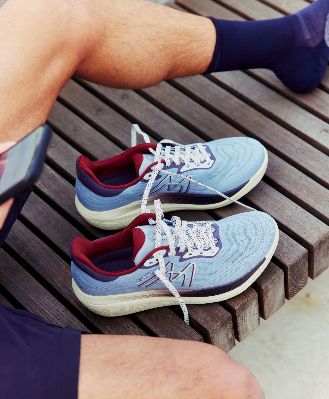 Male runner about to run with his KARHU ikoni 3.0 after sending a text